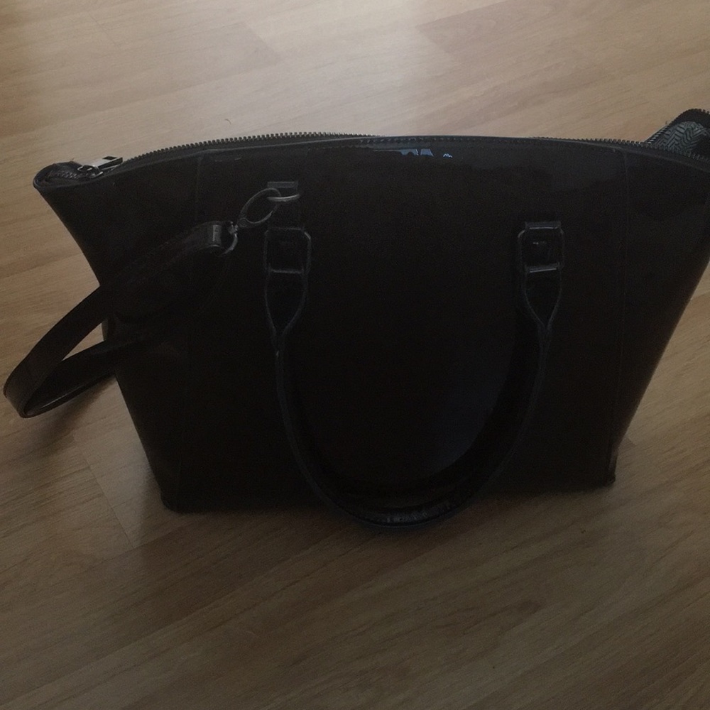 Cute purse with side handles and a strap.